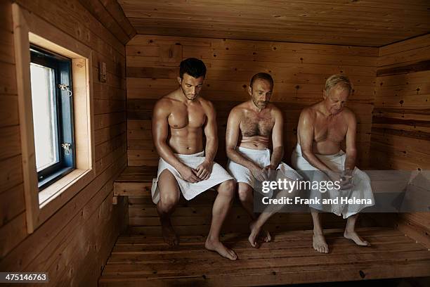 three men sitting in sauna with heads bowed - steam room stock pictures, royalty-free photos & images