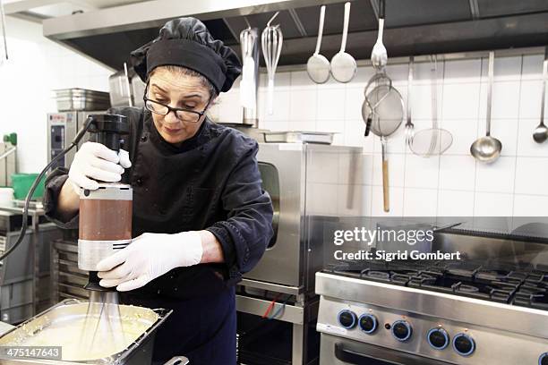 woman working in restaurant kitchen - kokkin stockfoto's en -beelden