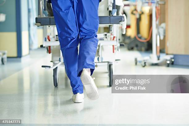 legs of medic running with gurney along hospital corridor - urgencias fotografías e imágenes de stock