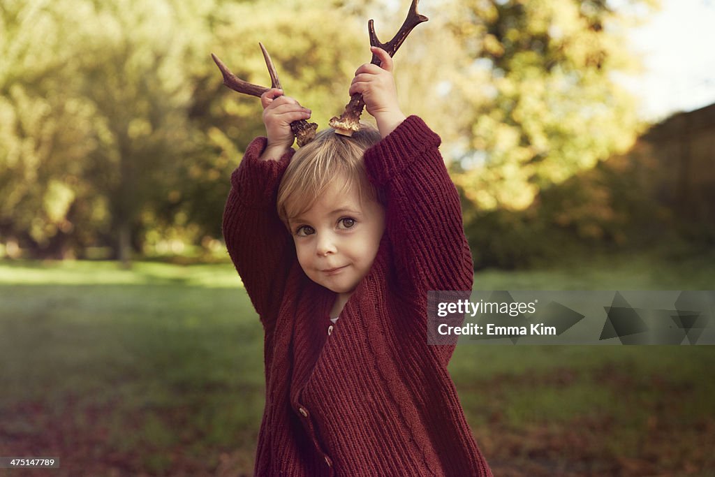 Toddler using sticks as antlers