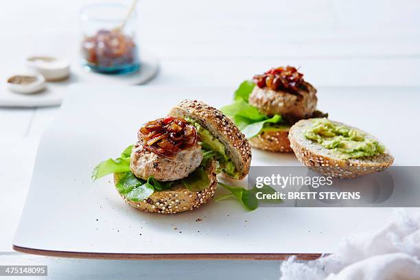 still life of chicken and avocado burgers - kipburger stockfoto's en -beelden