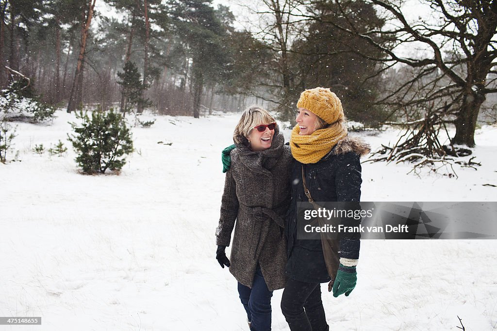 Mother and daughter walking in snow