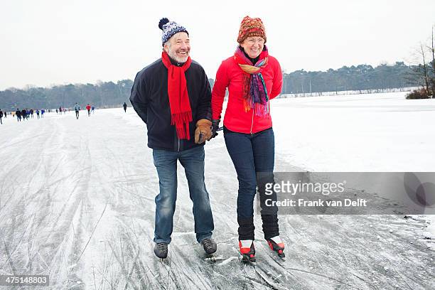 couple ice skating, holding hands - pattino da ghiaccio foto e immagini stock