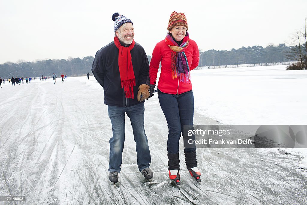 Couple ice skating, holding hands
