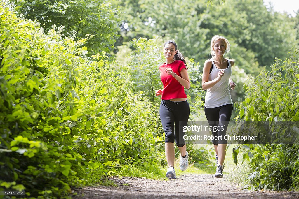 Women jogging through forest