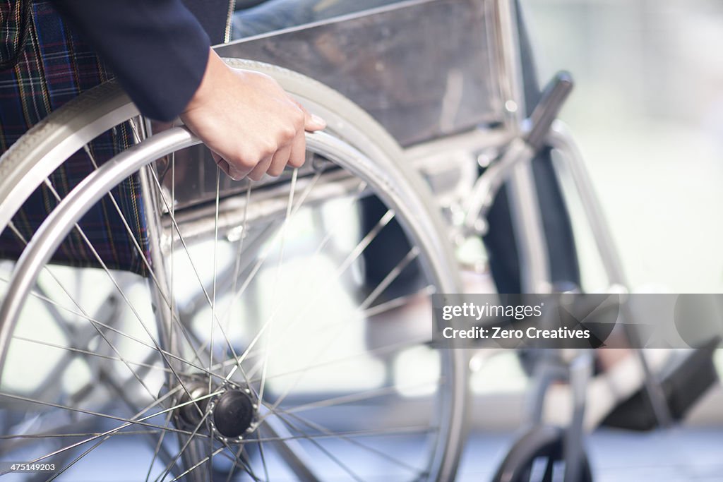 Woman turning wheel of wheelchair