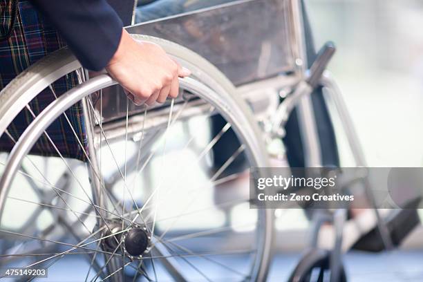 woman turning wheel of wheelchair - woman wheelchair stock pictures, royalty-free photos & images