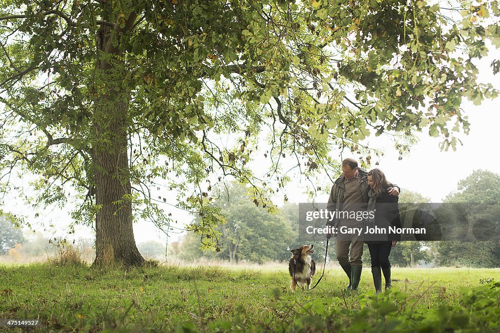 Senior couple walking dog, Norfolk, UK