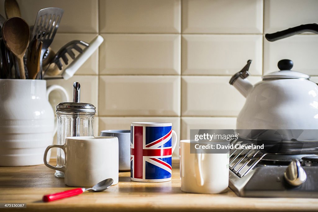 Kitchen counter with jug of utensils and coffee mugs