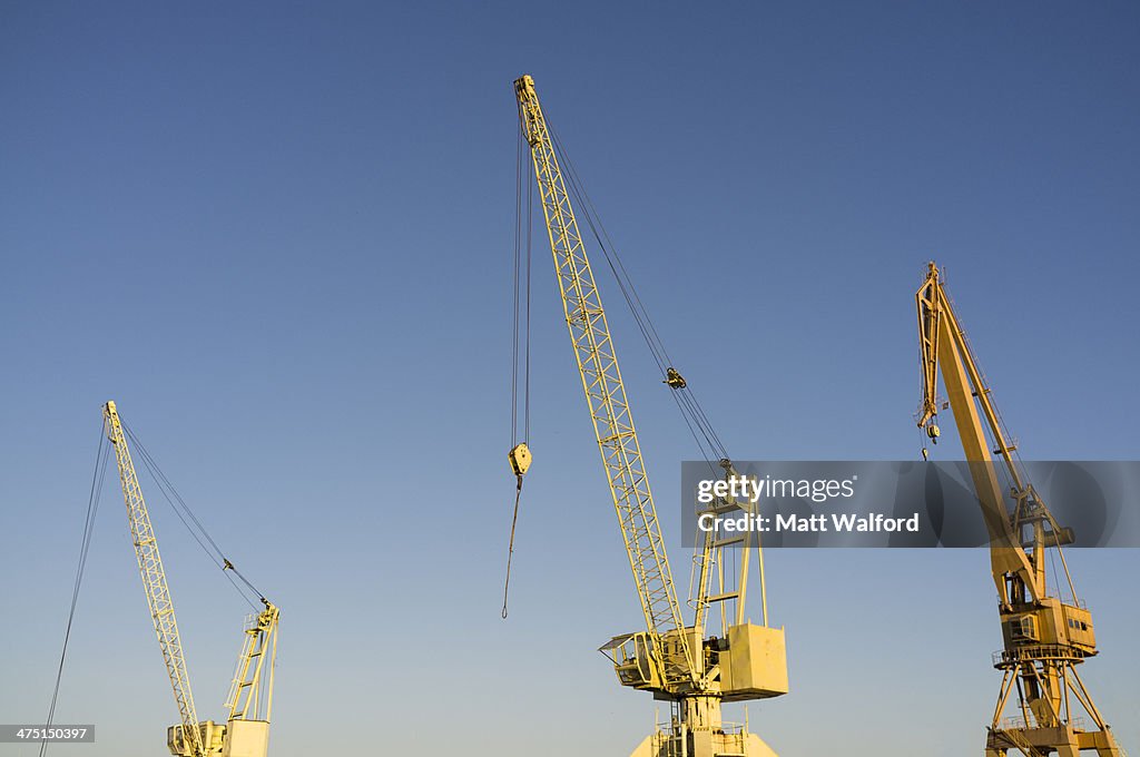 Yellow construction cranes in a row