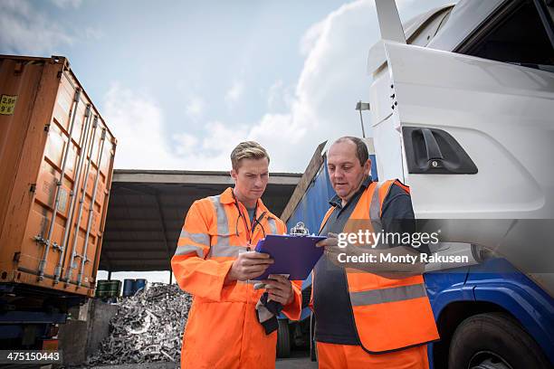 worker inspecting delivery paperwork with truck driver - truck driver stock pictures, royalty-free photos & images