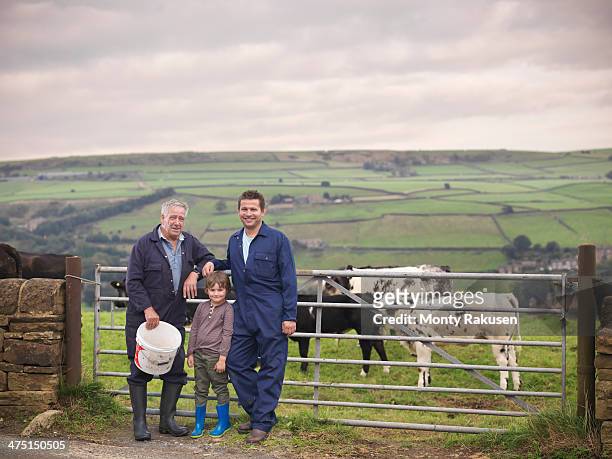 mature farmer, adult son and grandson standing together at gate to cow field, portrait - multi generation family portrait stock pictures, royalty-free photos & images