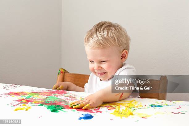 little boy playing with finger paints - toddler drawing stock-fotos und bilder