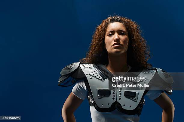 portrait of female american footballer wearing shoulder pads - padding stock pictures, royalty-free photos & images