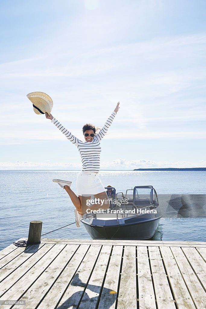 Young woman leaping mid air on pier, Gavle, Sweden