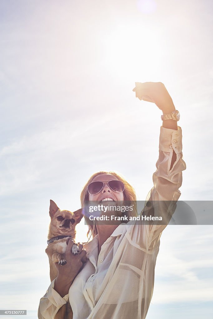 Young woman photographing herself with dog