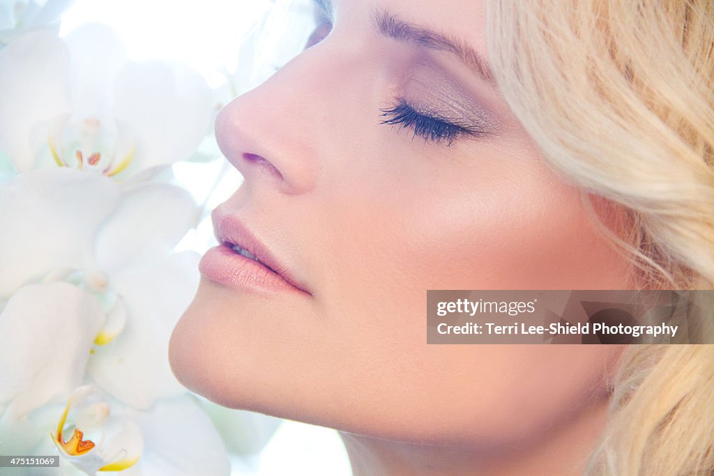 Close up of woman smelling orchids