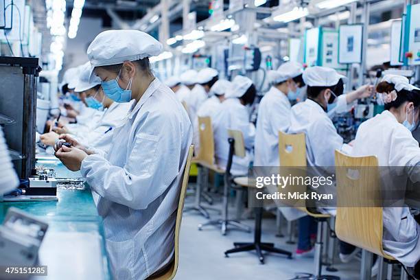 group of workers at small parts manufacturing factory in china, wearing protective clothing, hats and masks - blue collar worker mask stock pictures, royalty-free photos & images