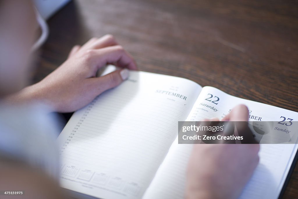 Close up of female writing in diary