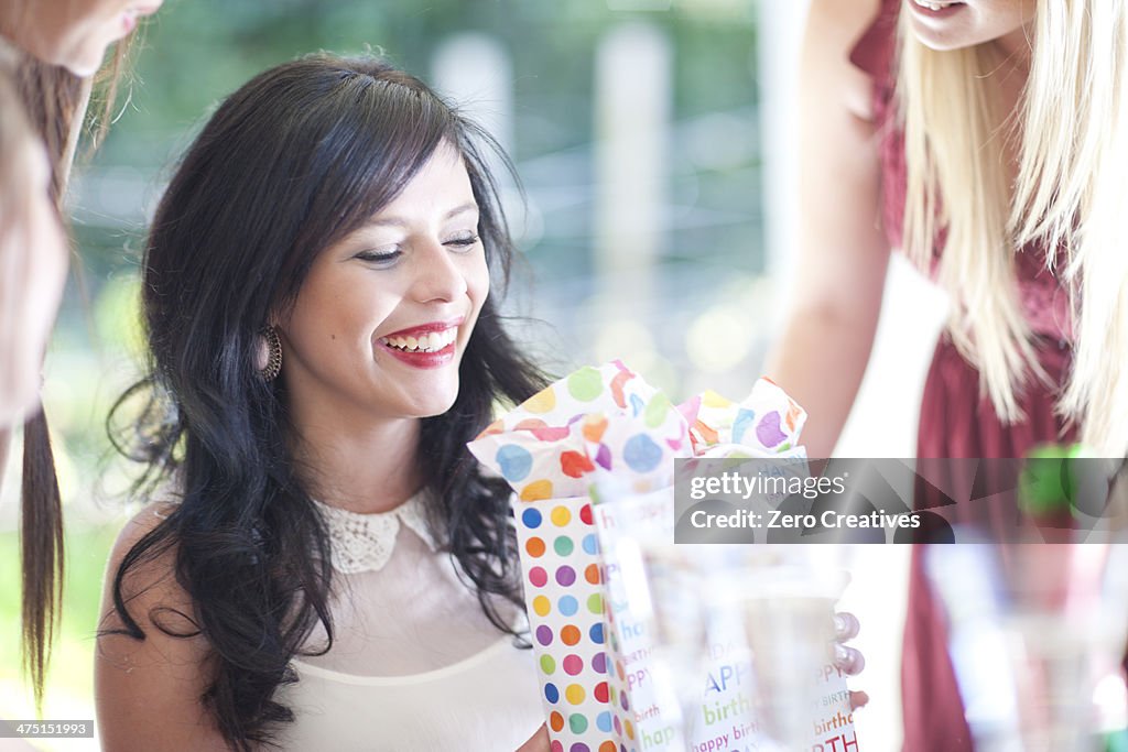 Young woman with friends and birthday present