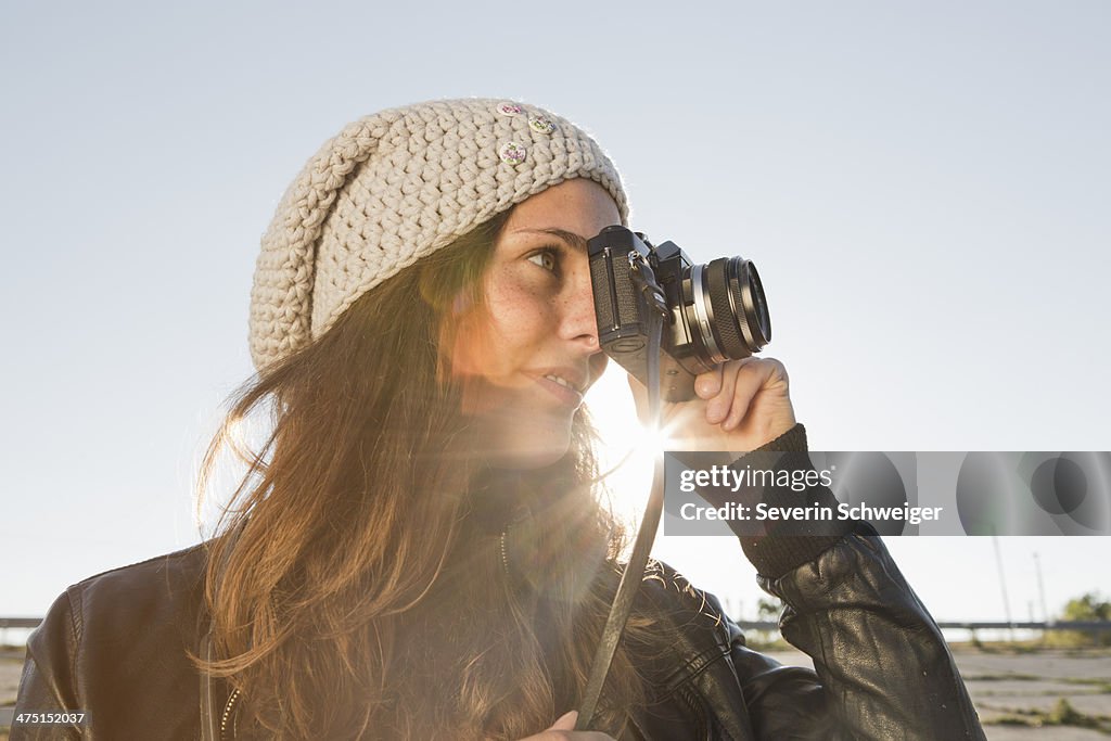 Portrait of young woman using slr camera