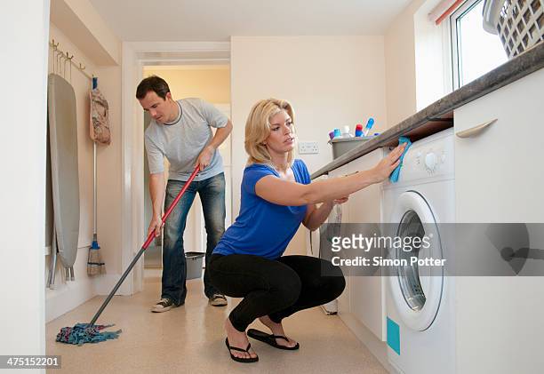 mid adult couple cleaning kitchen in new home - woman cleaning for man stock pictures, royalty-free photos & images