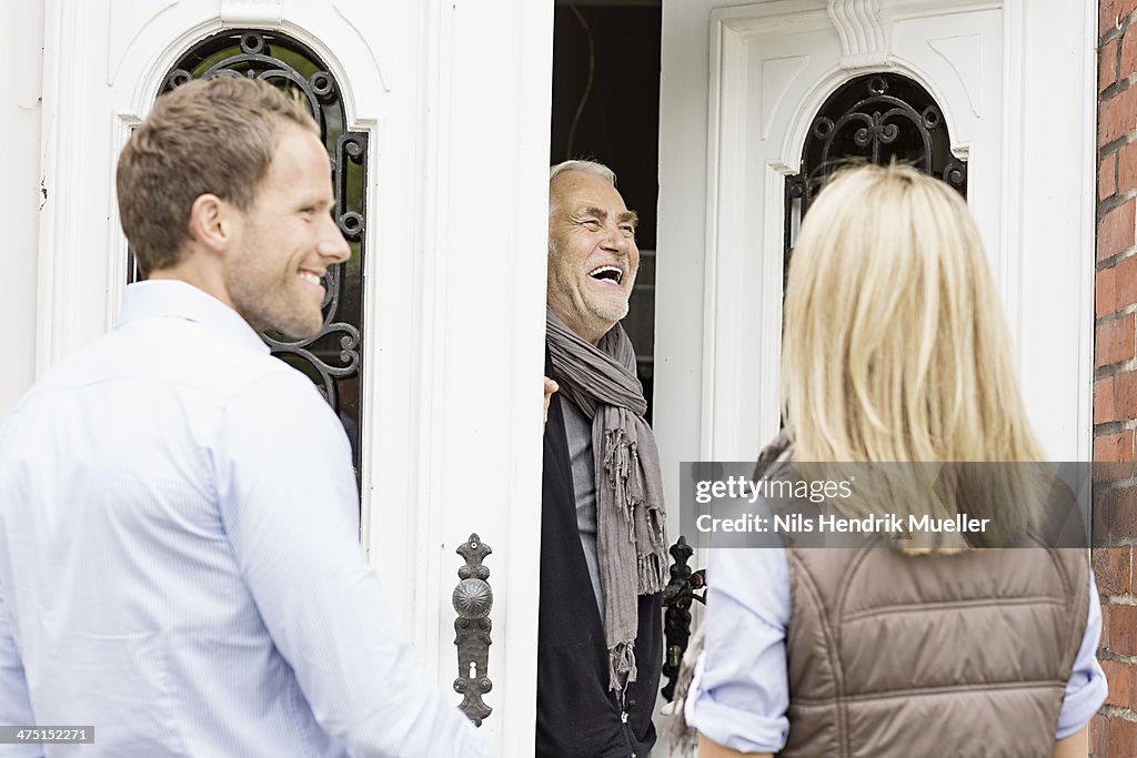 Father opening front door laughing