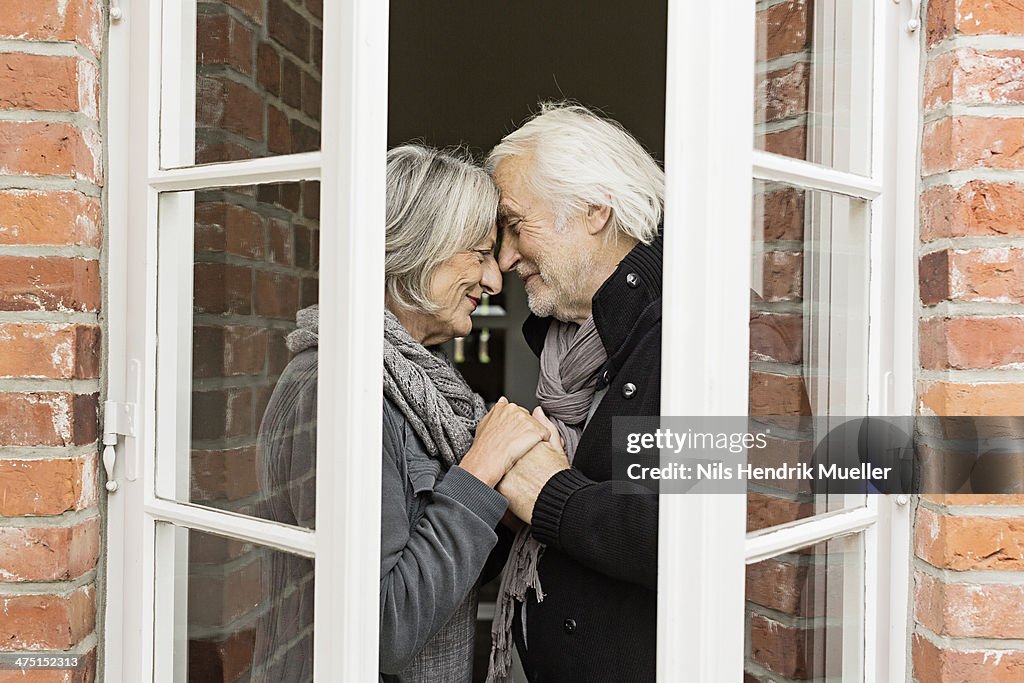 Senior couple face to face by window