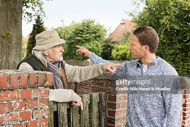 senior man and mid adult man arguing - discutir fotografías e imágenes de stock