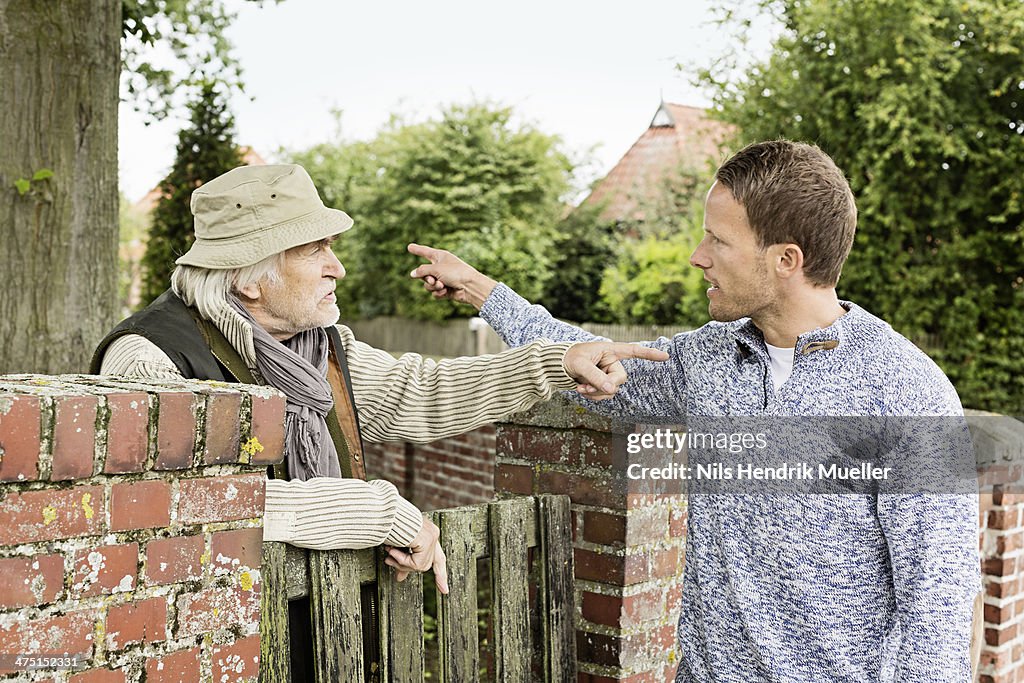 Senior man and mid adult man arguing