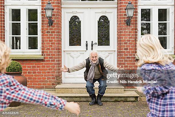 grandfather welcoming grandchildren with arms open - family greeting stock pictures, royalty-free photos & images