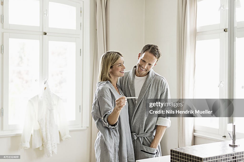 Mid adult couple, woman holding pregnancy test