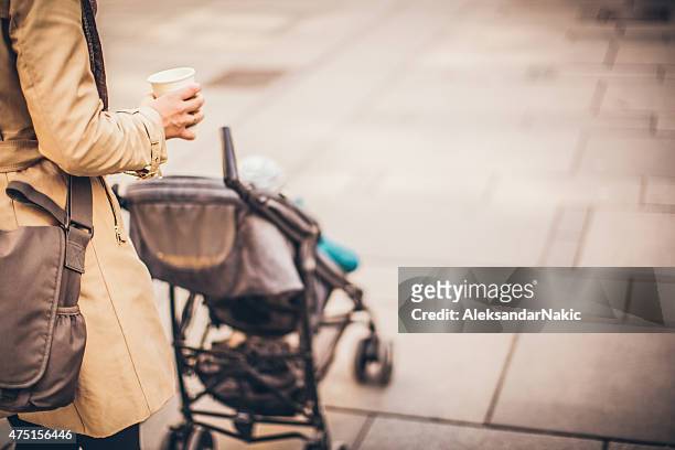 urban mom with a buggy - kinderwagen stockfoto's en -beelden