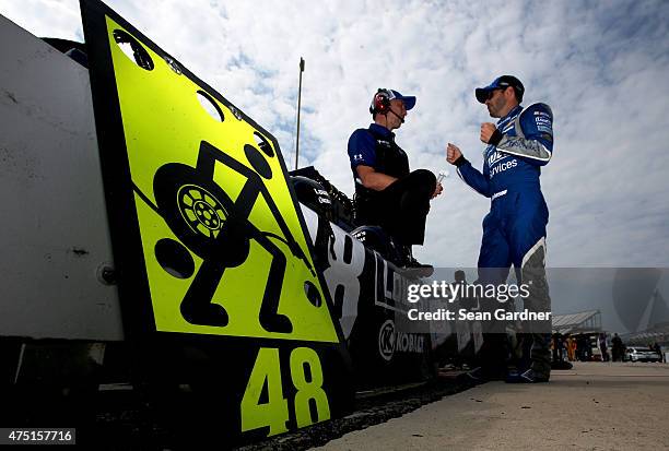 Jimmie Johnson, driver of the Lowe's Pro Services Chevrolet, right, talks with crew chief Chad Knaus on the grid during qualifying for the NASCAR...