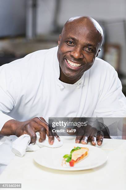 black chef in a restaurant plating food - chef headshot stock pictures, royalty-free photos & images