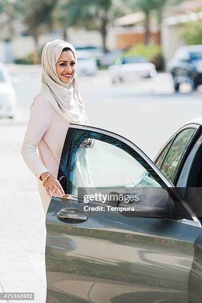 middle easter woman entering a luxury car in dubai - dubai woman driving car stockfoto's en -beelden