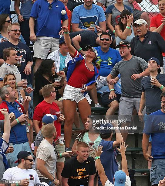 Fan in the left field bleachers throws back a home run ball hit by Salvador Perez of the Kansas City Royals during a game against the Chicago Cubs at...