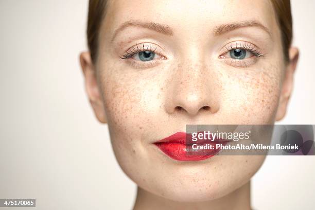 young woman wearing bright red lipstick, portrait - lächeln lippenstift stock-fotos und bilder