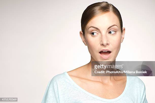 young woman looking away with mouth open in surprise, portrait - at a glance stock-fotos und bilder