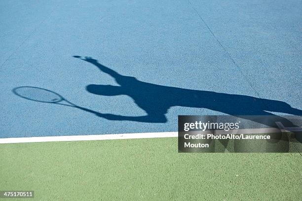 shadow of tennis player serving ball - tennis court ストックフォトと画像