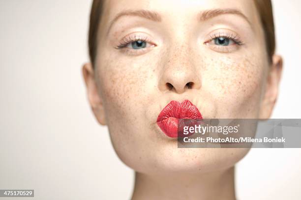 young woman puckering lips, portrait - lächeln lippenstift stock-fotos und bilder
