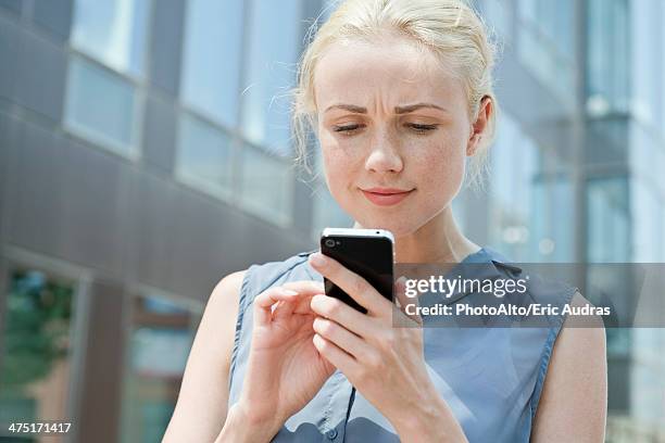 young woman using smartphone - confused woman stockfoto's en -beelden