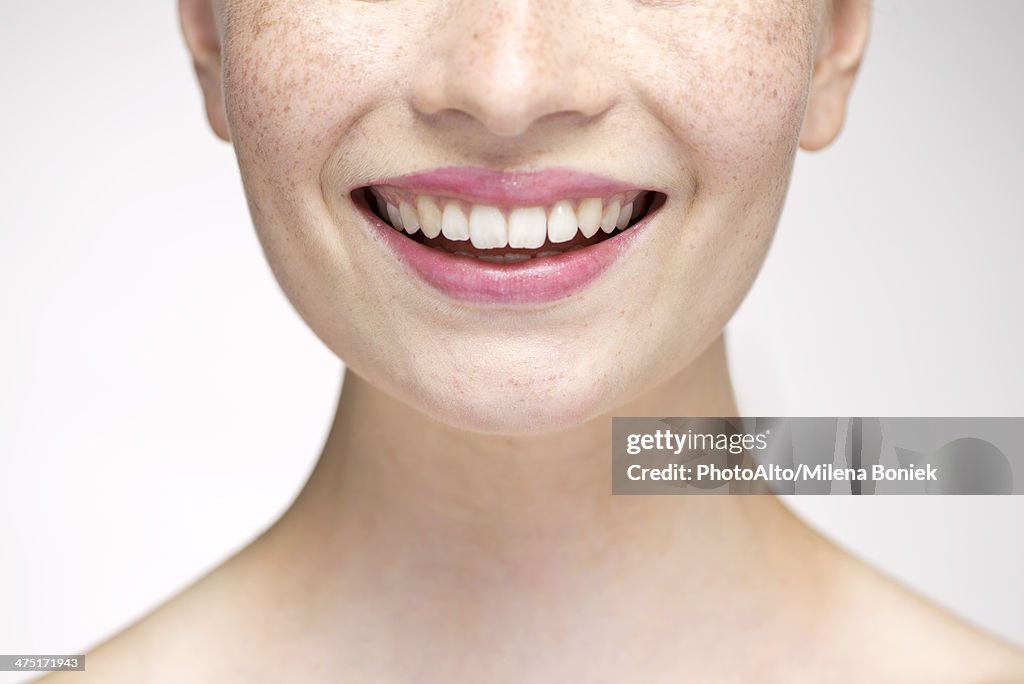 Young woman smiling, cropped portrait