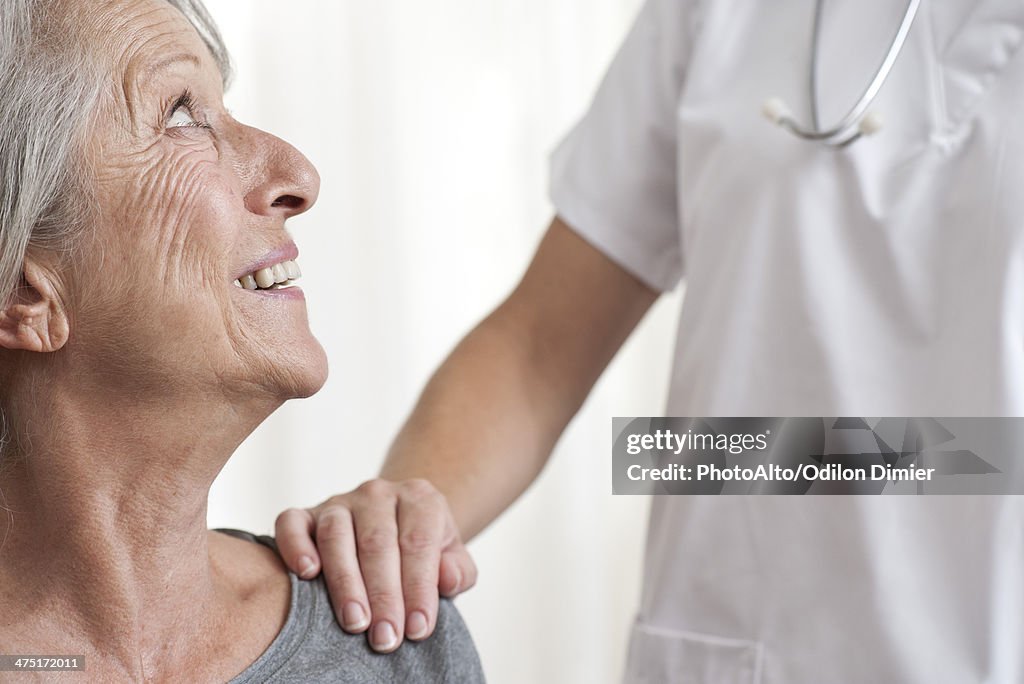 Woman being comforted by healthcare professional, cropped