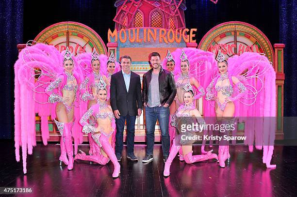 Sports Broadcaster Chris Fowler and Sports Commentator Jesse Palmer pose backstage with dancers at Le Moulin Rouge on May 29, 2015 in Paris, France.