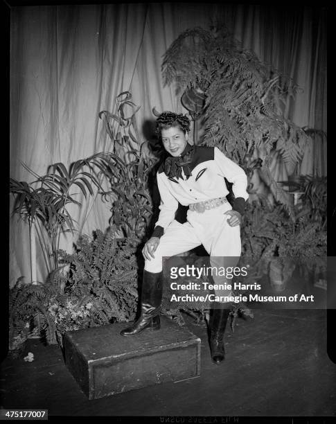 Nanette Frazier modeling riding clothes and Western style shirt, on stage with potted plants for sixth annual Beauty Shop Owners Fashion Show,...