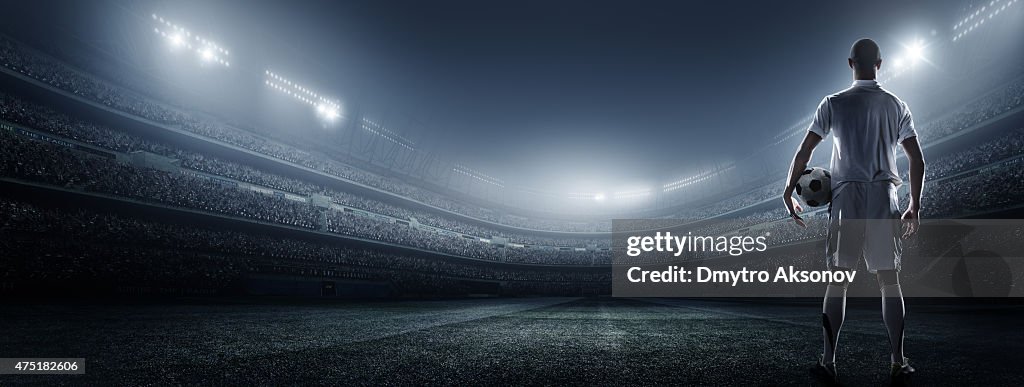 Soccer player with ball in stadium