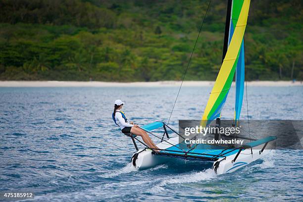 mujer joven navegando en catamarán por la playa caribeña - catamarán fotografías e imágenes de stock