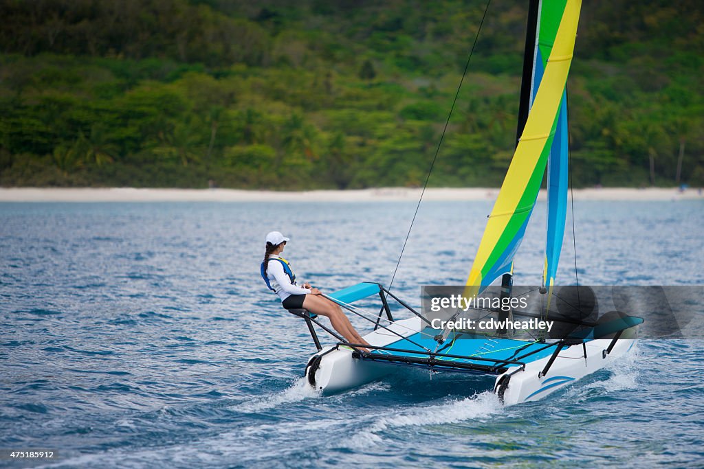 Jovem mulher navegando em um catamarã pela Caribbean beach