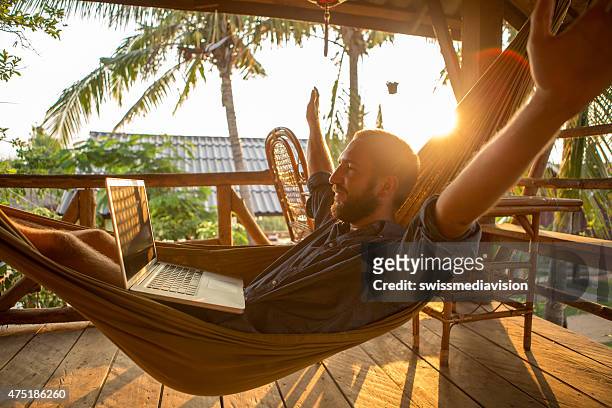 successful businessman on hammock with computer-sunset - time off work stock pictures, royalty-free photos & images